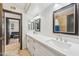 Bathroom featuring dual sinks, white cabinets, decorative mirror and a separate tiled shower at 7214 E Royal Palm Rd, Scottsdale, AZ 85258