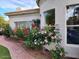 Charming home exterior adorned with vibrant rose bushes and red brick pathway at 7214 E Royal Palm Rd, Scottsdale, AZ 85258