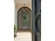 Close-up of the arched front door, featuring intricate ironwork and decorative wreath at 7214 E Royal Palm Rd, Scottsdale, AZ 85258
