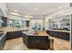 Spacious kitchen featuring granite counters, tile flooring, black cabinets, and views of the backyard at 7214 E Royal Palm Rd, Scottsdale, AZ 85258