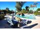 Luxurious pool area with rock waterfall, cozy seating, and lush landscaping for ultimate relaxation and enjoyment at 7214 E Royal Palm Rd, Scottsdale, AZ 85258