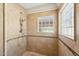 Shower stall with glass block window, tile walls, and hand held shower head at 7214 E Royal Palm Rd, Scottsdale, AZ 85258