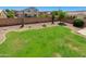 A spacious backyard featuring a large green lawn, desert landscaping, and block wall fencing at 7421 S 25Th Ln, Phoenix, AZ 85041