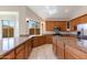 Open kitchen with granite countertops, wooden cabinets, and stainless steel appliances at 7421 S 25Th Ln, Phoenix, AZ 85041