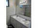 This bathroom features double sinks and ample counter space beneath a large mirror, blending style and functionality at 8117 W Dreyfus Dr, Peoria, AZ 85381