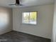 A bright bedroom with durable wood-look floors and a large window offering great natural light and street views at 8117 W Dreyfus Dr, Peoria, AZ 85381