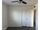 This bedroom features a ceiling fan, gray laminate floors, and a large closet at 8117 W Dreyfus Dr, Peoria, AZ 85381