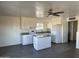 Well-lit kitchen boasting granite countertops, a functional island, and sleek white cabinets for ample storage at 8117 W Dreyfus Dr, Peoria, AZ 85381