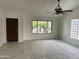 Bright living room with tile flooring, ceiling fan, and large window overlooking the front yard at 8117 W Dreyfus Dr, Peoria, AZ 85381
