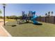 Community playground featuring a blue spiral slide, black climbing structures, and a soft green surface at 8301 N 21St Dr # F102, Phoenix, AZ 85021