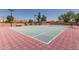 Outdoor tennis court with red and green surface and chain-link fence, surrounded by trees and community buildings at 8301 N 21St Dr # F102, Phoenix, AZ 85021