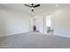 Spacious carpeted bedroom with ceiling fan, white walls, and easy access to en suite bathroom at 9626 E Bunny Ear E Ln, Gold Canyon, AZ 85118
