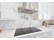 Close up of a modern kitchen featuring white cabinets, quartz countertops, and stainless steel hood at 9626 E Bunny Ear E Ln, Gold Canyon, AZ 85118