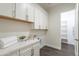 Spacious laundry room features bright white cabinets, quartz countertop, and a convenient folding area at 9626 E Bunny Ear E Ln, Gold Canyon, AZ 85118