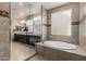 Bathroom featuring a double sink vanity, granite countertops, tile floors, and soaking tub at 9747 W Sands Dr, Peoria, AZ 85383
