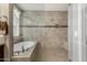 Bathroom featuring a soaking tub, walk-in shower with tile surround, and a window at 9747 W Sands Dr, Peoria, AZ 85383