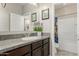 Bathroom showcasing a granite countertop, wood cabinets, and a tub with a shower at 9747 W Sands Dr, Peoria, AZ 85383