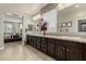 Bathroom with a double sink vanity, granite countertop, and access to the main bedroom at 9747 W Sands Dr, Peoria, AZ 85383
