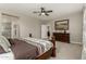 Comfortable bedroom featuring a ceiling fan, dresser and access to the en-suite bathroom at 9747 W Sands Dr, Peoria, AZ 85383
