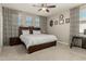 Bedroom featuring a decorative bed frame, patterned curtains, and a ceiling fan at 9747 W Sands Dr, Peoria, AZ 85383