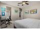Bedroom featuring a ceiling fan, desk, and access to an ensuite bathroom at 9747 W Sands Dr, Peoria, AZ 85383