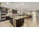 Open kitchen with dark cabinets, granite countertops, stainless appliances, and views of the living area at 9747 W Sands Dr, Peoria, AZ 85383