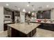 Updated kitchen with dark cabinets, stainless steel appliances, a spacious island and stylish backsplash at 9747 W Sands Dr, Peoria, AZ 85383