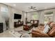Inviting living room with leather furniture, recessed lighting, ceiling fan and decorative patterned curtains at 9747 W Sands Dr, Peoria, AZ 85383