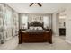 Elegant main bedroom with a decorative, dark wood bed frame and patterned curtains at 9747 W Sands Dr, Peoria, AZ 85383