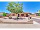 Charming single-story home featuring a well-maintained front yard, xeriscaping, and cozy patio seating at 1018 S Toltec --, Mesa, AZ 85204