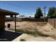 Backyard with grass and weeds and partially covered patio at 1039 E Broadway Rd, Mesa, AZ 85204