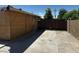 Long concrete driveway leading to a wooden gate with privacy fence on each side at 1039 E Broadway Rd, Mesa, AZ 85204