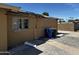 Exterior of property with damaged section, trash bins and brick pavers at 1039 E Broadway Rd, Mesa, AZ 85204