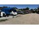 Exterior view of the property, showing vehicles and a blue tarp structure at 1039 E Broadway Rd, Mesa, AZ 85204