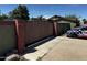 A closed wooden gate between red brick columns secures the property at 1039 E Broadway Rd, Mesa, AZ 85204