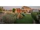 Lush backyard with artificial turf, play structure, and a covered patio perfect for outdoor fun at 10822 W Quail Ave, Peoria, AZ 85373