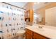 Bathroom with a single sink vanity, medicine cabinet, and patterned shower curtain at 10822 W Quail Ave, Peoria, AZ 85373