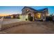 Dusk view of a home featuring desert landscaping and a well-lit two-car garage with an extra long driveway at 10822 W Quail Ave, Peoria, AZ 85373