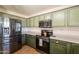 Kitchen boasts stainless steel appliances, green cabinets, and plenty of counter space at 10822 W Quail Ave, Peoria, AZ 85373