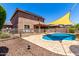 Wide view of the backyard pool with rock landscaping and a safety fence at 13123 W Cottontail Ln, Peoria, AZ 85383