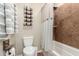 Bathroom with tiled shower-tub combination, toilet, and towel racks, providing a functional space at 13123 W Cottontail Ln, Peoria, AZ 85383