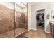 Beautiful bathroom featuring a tiled walk-in shower with a glass door and a spacious walk-in closet at 13123 W Cottontail Ln, Peoria, AZ 85383