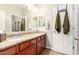 Bathroom featuring double sinks, granite countertops and matching cabinetry with hanging olive-green towels at 13123 W Cottontail Ln, Peoria, AZ 85383