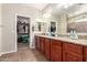 Bathroom featuring dual sinks, granite countertop, and a walk-in closet with ample storage space at 13123 W Cottontail Ln, Peoria, AZ 85383