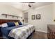 Cozy bedroom featuring a plush bed with blue bedding, ceiling fan, and decorative sunflower artwork at 13123 W Cottontail Ln, Peoria, AZ 85383