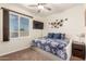 Bedroom featuring a trundle daybed with blue floral bedding, modern wall art and a window view at 13123 W Cottontail Ln, Peoria, AZ 85383