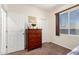 This bedroom has a dresser with decorations, two closet doors, and a window with a view at 13123 W Cottontail Ln, Peoria, AZ 85383