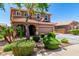 Charming two-story home features a well-manicured front yard with lush greenery and a welcoming facade under a clear blue sky at 13123 W Cottontail Ln, Peoria, AZ 85383