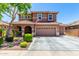 Charming two-story home with a three-car garage, desert landscaping, and an American flag at 13123 W Cottontail Ln, Peoria, AZ 85383