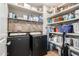 Well-organized laundry room with black appliances and ample storage shelving space at 13123 W Cottontail Ln, Peoria, AZ 85383